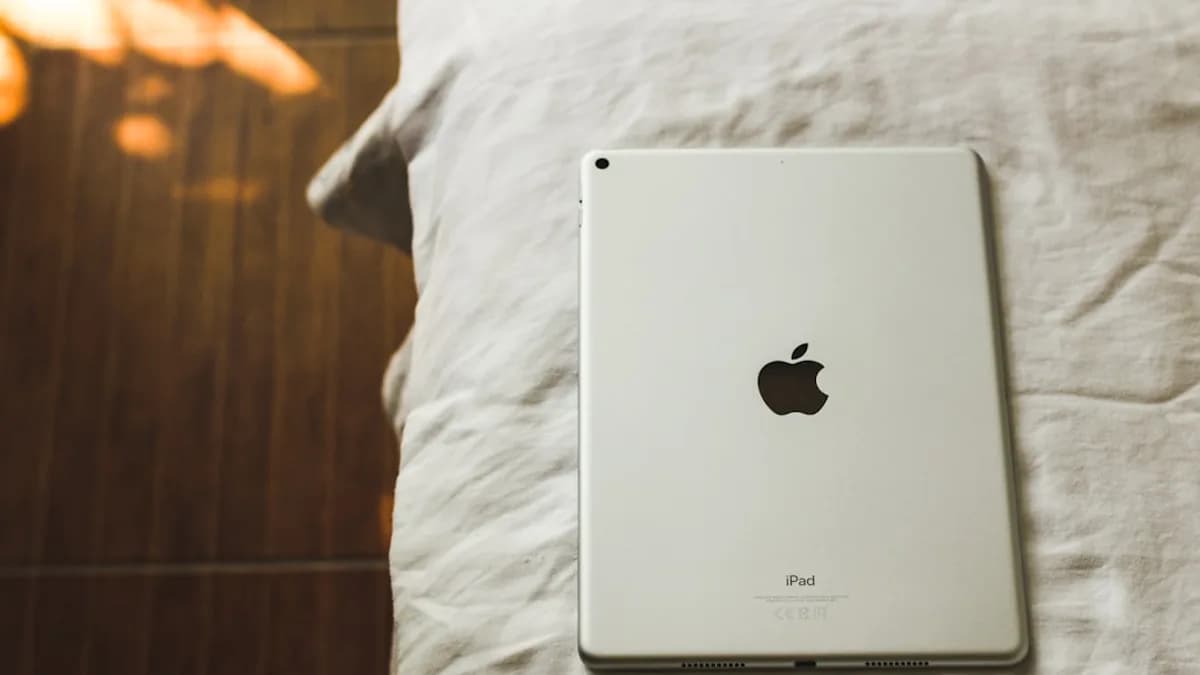 an apple ipad sitting on top of a bed