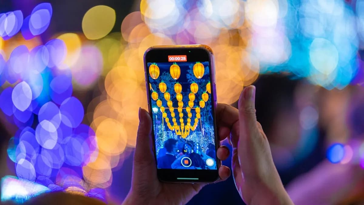 a person holding up a cell phone in front of a blurry background