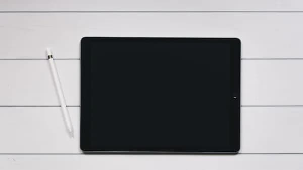 space gray iPad with Apple Pencil with white and black pinstriped background