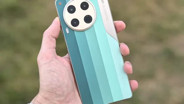 A hand holds a smartphone with four cameras.