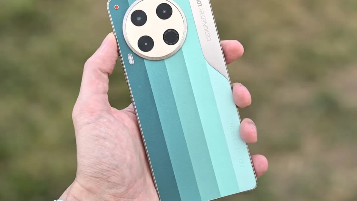 A hand holds a smartphone with four cameras.