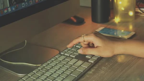a person typing on a keyboard on a desk