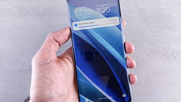A hand holds a smartphone with a blue display.