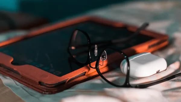 a pair of glasses sitting on top of a tablet