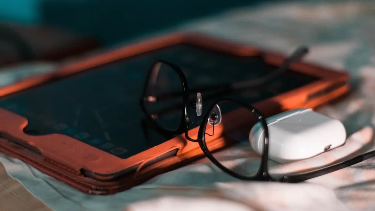 a pair of glasses sitting on top of a tablet