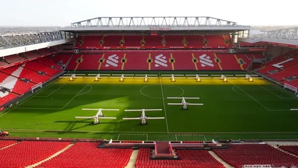 a soccer stadium with a green field and red seats
