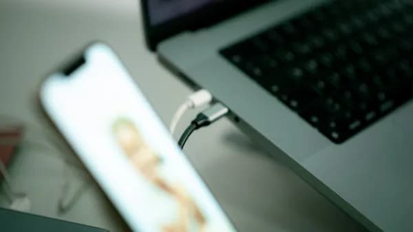 a close up of a cell phone near a laptop