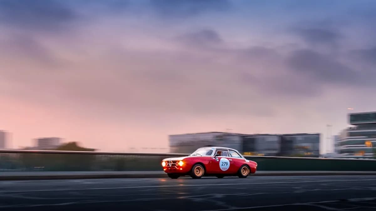 A red and white car driving down a street