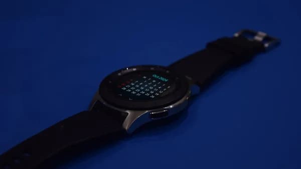 A smart watch sitting on top of a blue surface
