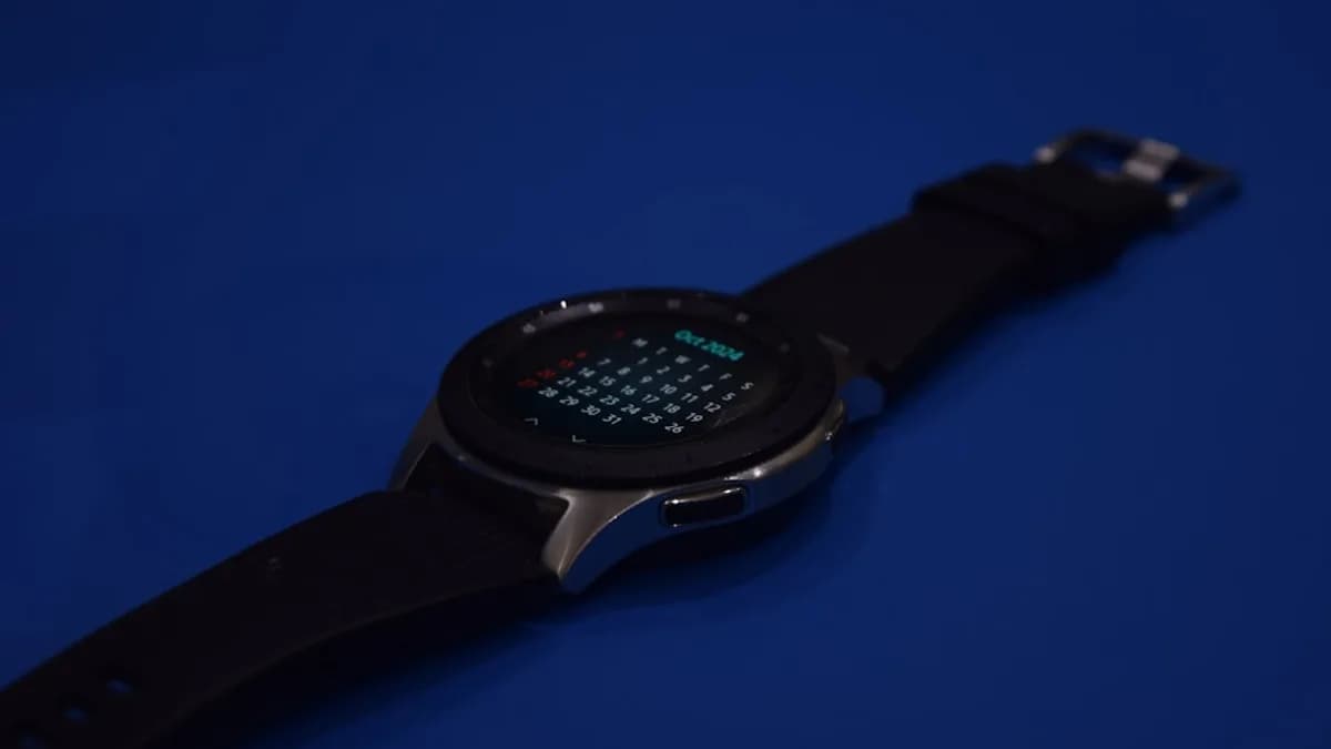 A smart watch sitting on top of a blue surface