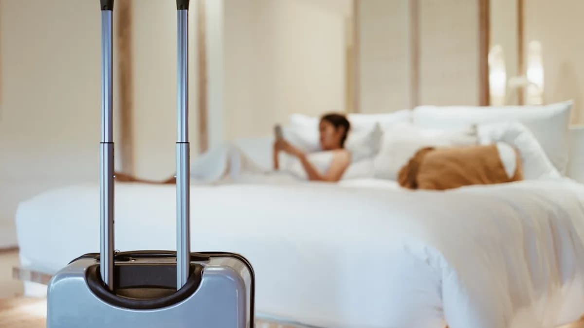 a woman laying on a bed with a suitcase in front of her