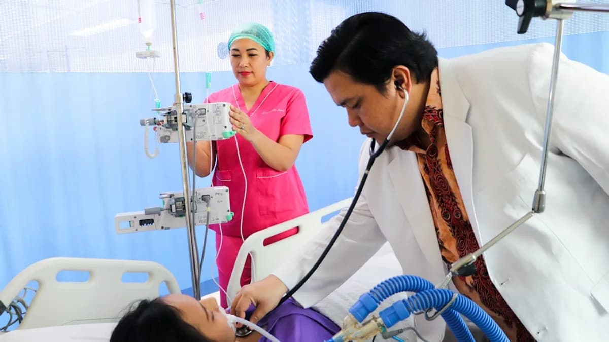 a man laying in a hospital bed being examined by a nurse