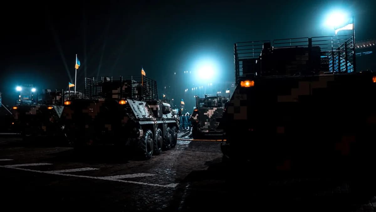 military vehicles parked in a parking lot at night