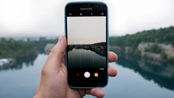 person taking photo of body of water