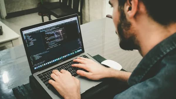 man programming using laptop
