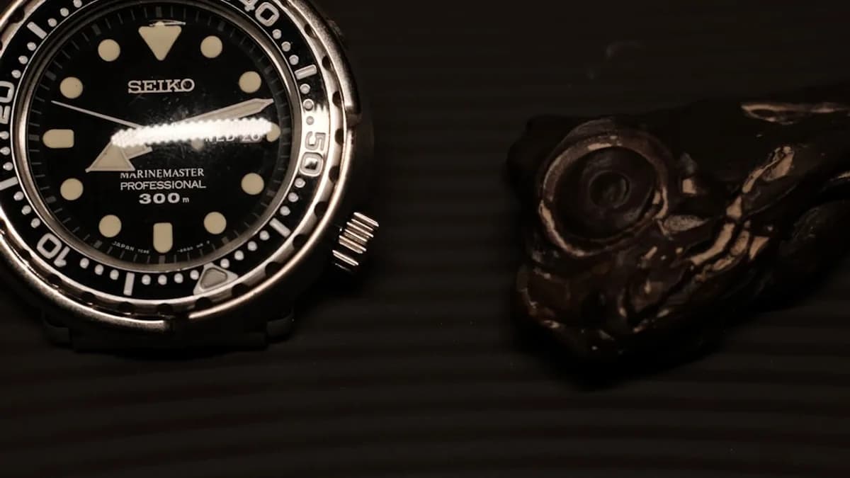 a watch sitting on top of a table next to a knife