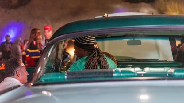 man in green and black plaid shirt driving car