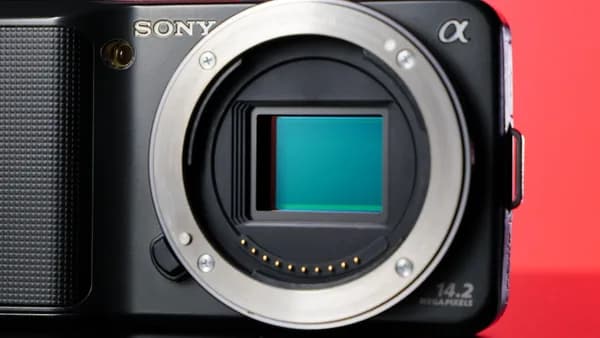 a black camera with a green screen on a table