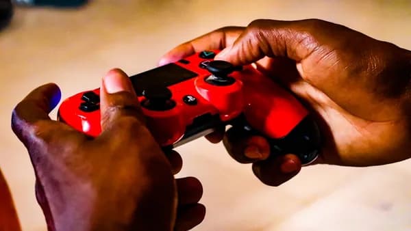 person holding red and black game controller