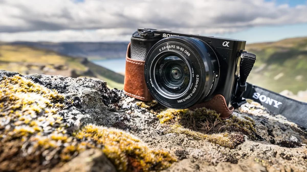 A black sony camera rests on a rocky outcrop.
