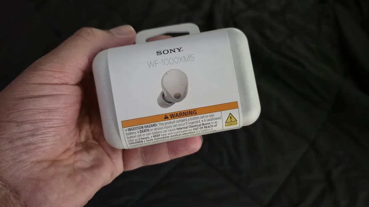 Sony earbuds in original packaging held by hand