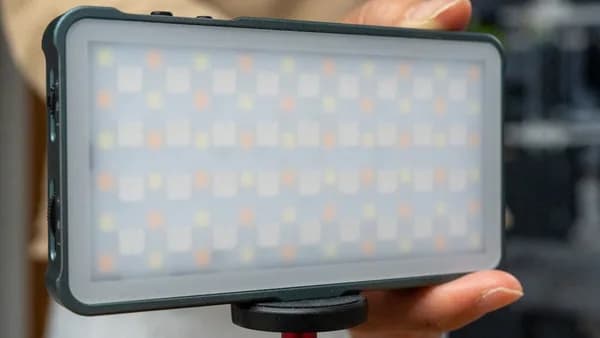 A person holding a camera with a light on it