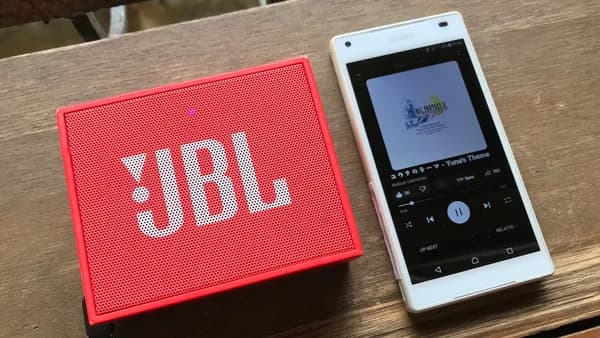 Jbl speaker and phone playing music.
