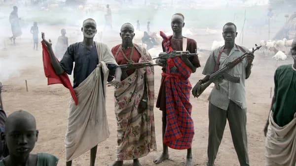 four men holding assault rifles