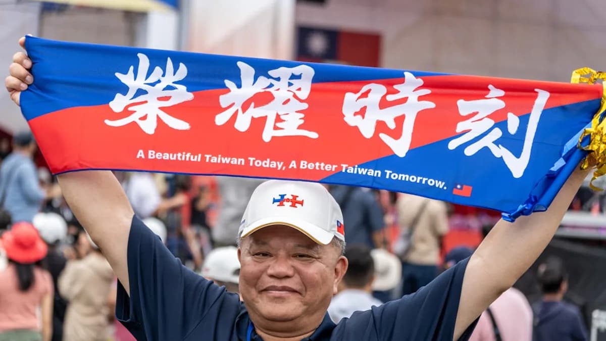 A man holding up a blue and red scarf