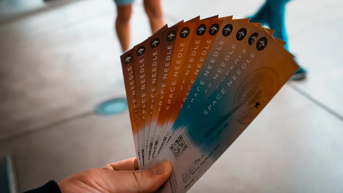 person holding brown, blue, and white tickets