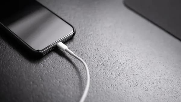 black smartphone with charger cord connected