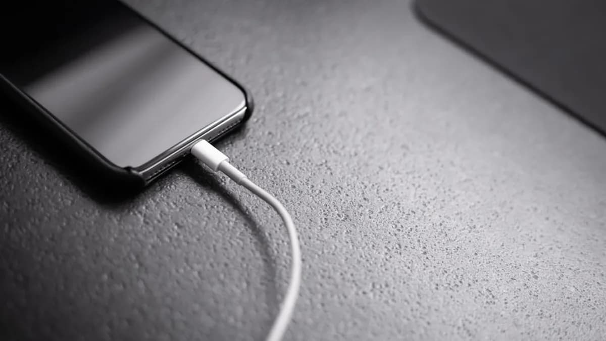 black smartphone with charger cord connected