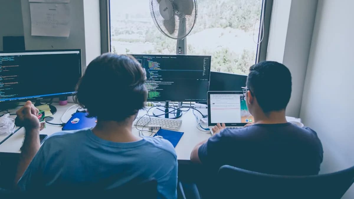 two men using computer and laptop