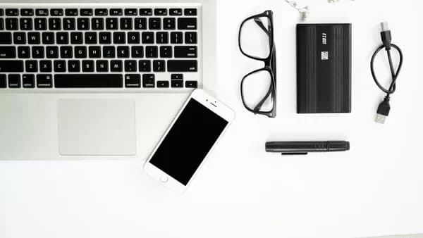 white iphone 5 c beside macbook pro