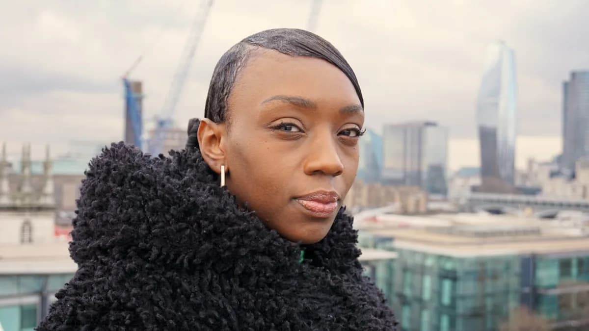 a woman in a black coat looking at the camera