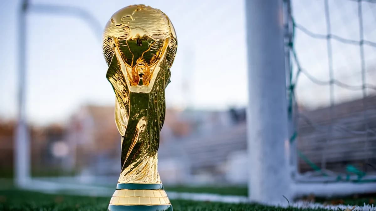 a golden soccer trophy sitting on top of a field