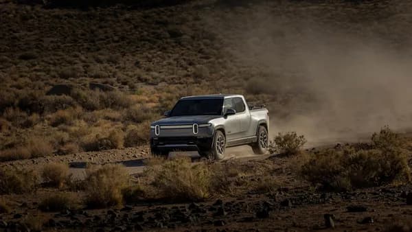 a white truck driving down a dirt road