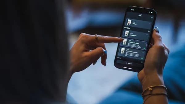 Woman using a smartphone with a smart home app.