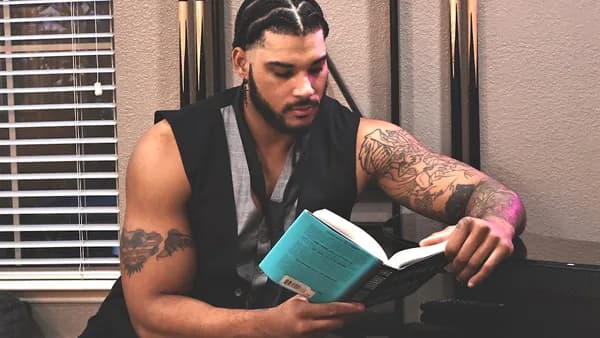 A man is relaxing while reading a book.