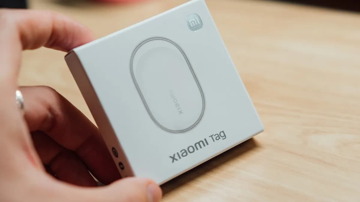 Hand holding a white box with "xiaomi tag" printed