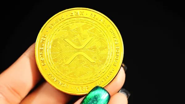 gold round coin on persons hand