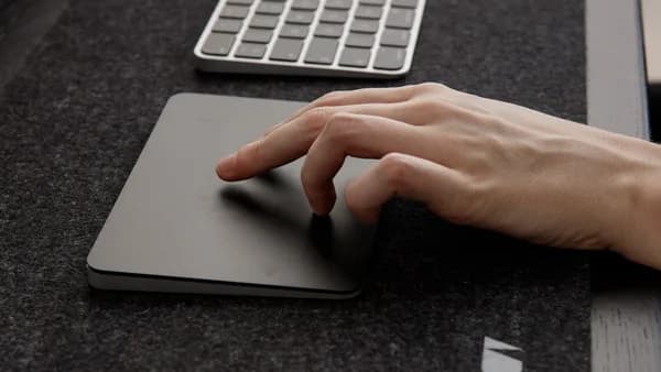 a person's hand on a mouse pad next to a keyboard