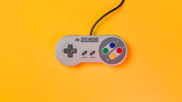 white nintendo game controller on yellow surface
