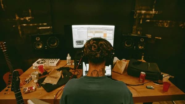 a man sitting at a desk with a guitar in front of him