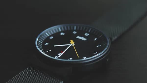 round black Braun analog watch with black band at 7:30