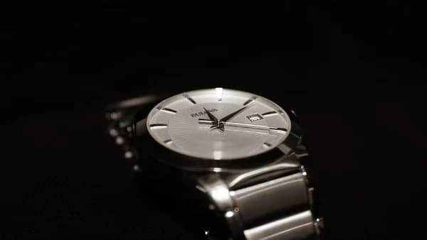 a silver watch with a black background