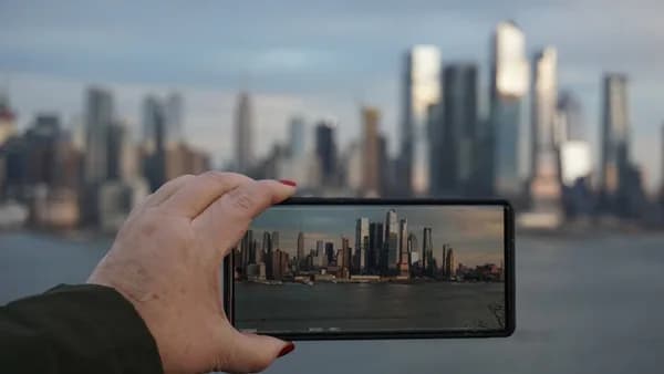 A person taking a picture of a city with a cell phone