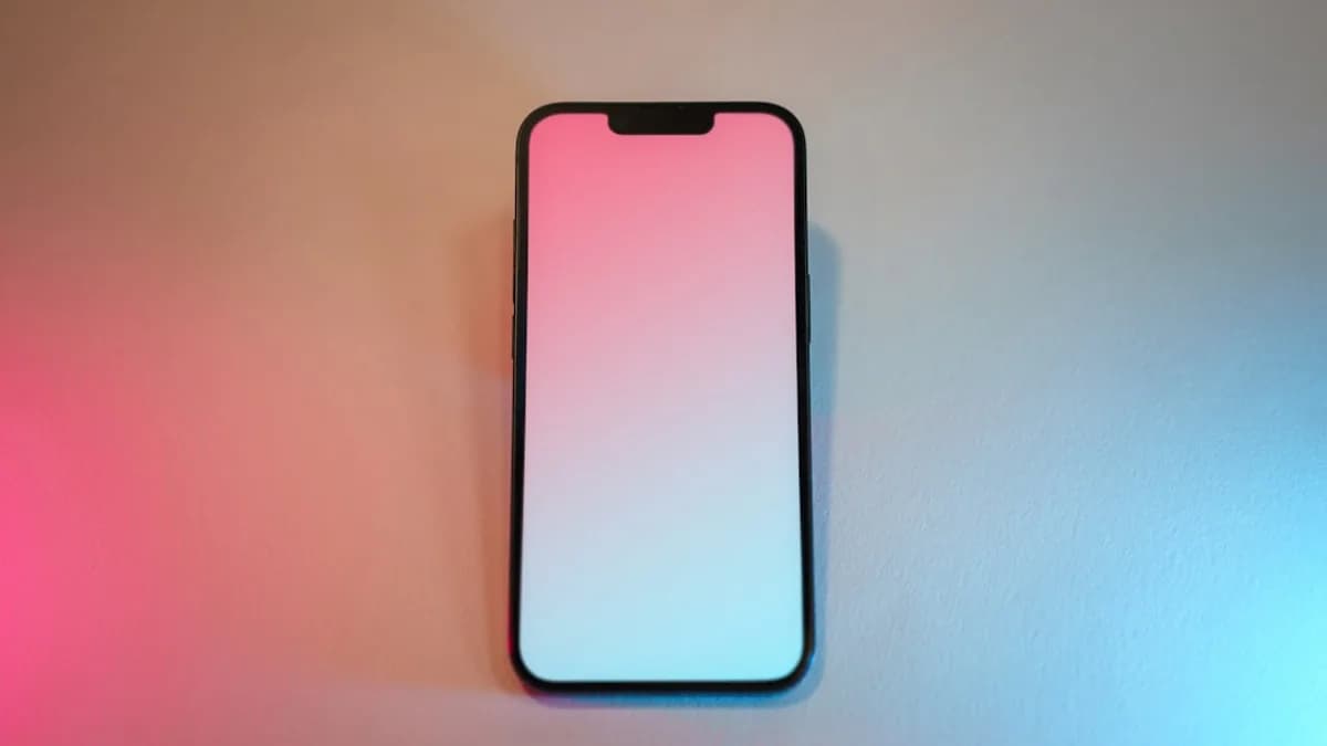 A pink and white cell phone sitting on top of a table
