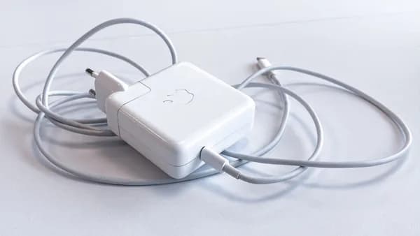 white apple charging adapter on white table