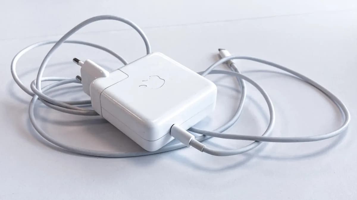 white apple charging adapter on white table